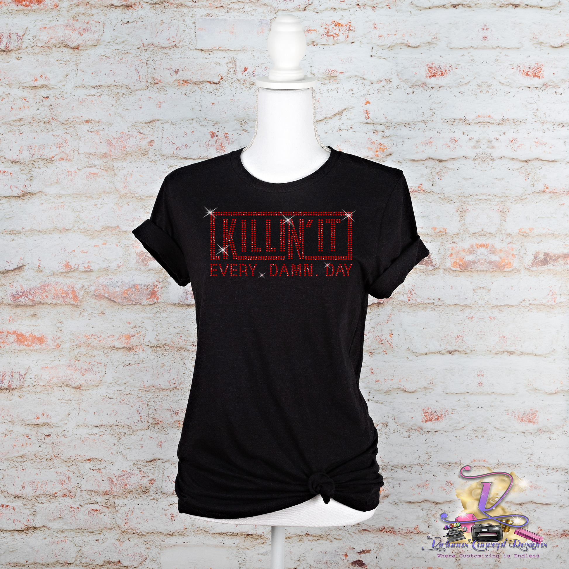 The black t-shirt from My Store, titled "Killin it," exudes bold style as it is displayed on a mannequin against a brick wall. The design features red text with a thin border that reads "KILLIN IT EVERY DAMN DAY." The shirt is stylishly knotted at the bottom, and a logo can be seen in the bottom right corner.